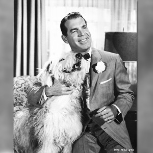 photo of actor Fred MacMurray seated holding a large shaggy dog