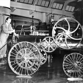 photo of Walt Disney working levers at the font of a steam powered fire engine on display while visiting Chicago Railroad Fair in 1948