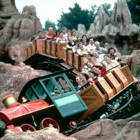 photo of Disneyland thrill ride Big Thunder Mountain Railroad carrying guests around a tight banked curve