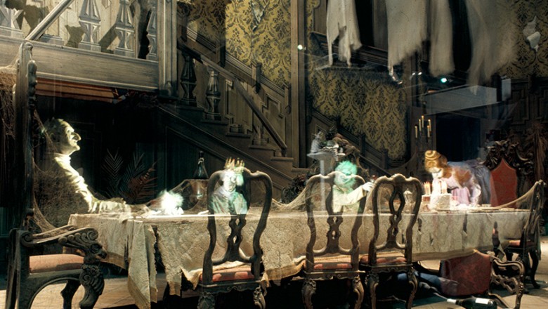 photo of Haunted Mansion Dining Room in Disneyland attraction showing ghostly apparitions seated at long formal dining table in a great hall