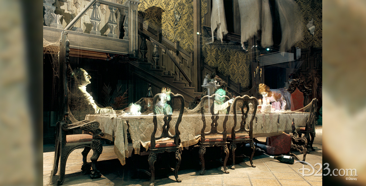 photo of Haunted Mansion Dining Room in Disneyland attraction showing ghostly apparitions seated at long formal dining table in a great hall