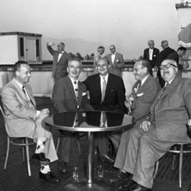 photo of men in suits sharing laughs on the rooftop penthouse club of the animation building