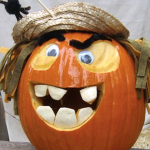 photo of carved and painted Jack O Lantern with added eyebrows and hat