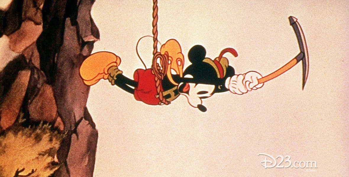 still of Mickey in climber gear dangling from a rope in Alpine Climbers