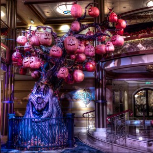 photo of gnarled tree sprouting many purple pumpkin jack-o-lanterns