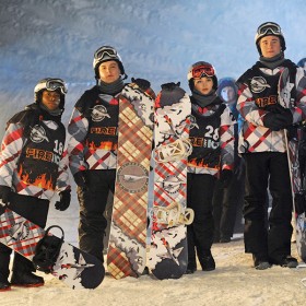 photo of group of young people dressed for winter sports, each person holding a snowboard