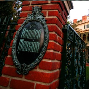 photo of entrance gate and bronze sign for Haunted Mansion at Disneyland