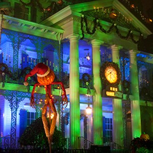 photo of The Haunted Mansion at Disneyland Resort decorated and all lit up for the holidays