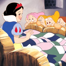 cel from animated classic Snow White and the Seven Dwarfs showing the seven dwarfs all huddled at the foot of Snow White's bed