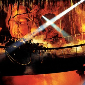 photo of guests in ride vehicle on wobbly rope bridge passing through fire in underground cavern on Indiana Jones Adventure at Disneyland Resort