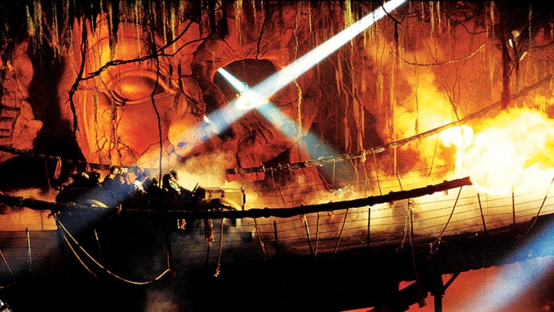 photo of guests in ride vehicle on wobbly rope bridge passing through fire in underground cavern on Indiana Jones Adventure at Disneyland Resort