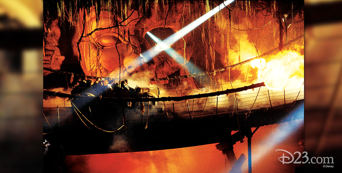 photo of guests in ride vehicle on wobbly rope bridge passing through fire in underground cavern on Indiana Jones Adventure at Disneyland Resort