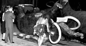 photo of giant Mammoth legs in the air, marked with a sign Christmas Turkey and a life-size cave man figure standing near it