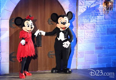 Minnie Mouse and Mickey Mouse at castle double doors each with a hand grasping a door handle ready to pull them open