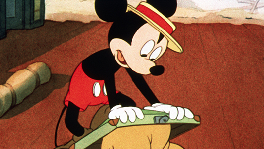 cel from cartoon featuring Mickey Mouse trying to stuff Pluto into his valise in order to sneak him on board a train