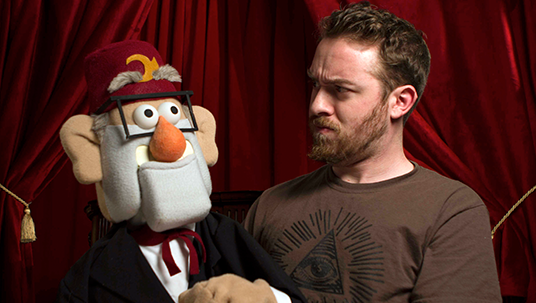 photo of Gravity Falls creator and executive producer Alex Hirsch with life-size Grunkle Stan character