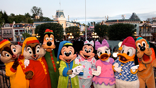 group photo of seven Disney cast member characters Chip, Dale, Goofy, Mickey Mouse, Minnie Mouse, Daisy Duck, Donald Duck, and Pluto all lined up with Disneyland Main Street behind