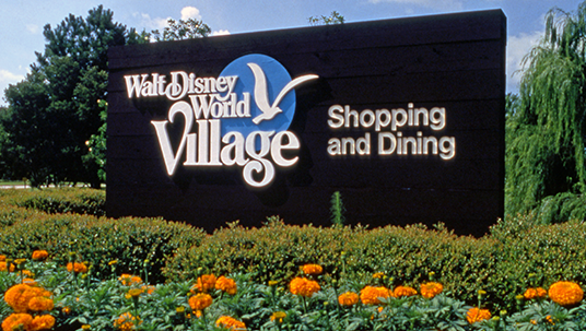 photo of large entrance sign with text Walt Disney World Village Shopping and Dining