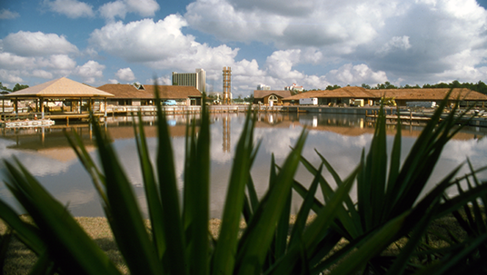 photo of construction of pavilion and other structures as seen from across a small lake