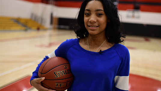 photo of Mo’ne Davis holding a basketball in a gymnasium