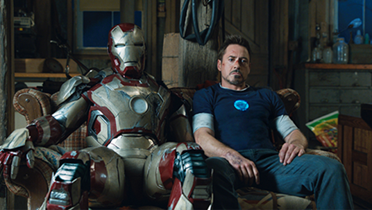 movie still of actor Robert Downey Jr. seated next to his Iron Man double