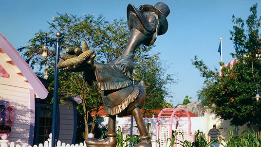 The large, memorable statue of Cornelius Coot would hold over into Mickey’s Starland in 1990, and Mickey’s Toontown Fair in 1996 (though with a new, corncob shaped base, pictured here). After the closing of the Fair in early 2011, the statue of Coot was safely transitioned to the Walt Disney Archives where it proudly resides today as a fun (and heavy) reminder of the growth and change that has occurred in that section of Magic Kingdom Park. It’s a fine piece of Disney craftsmanship and history, representing more than 20 years of fun-filled and whimsical memories.
