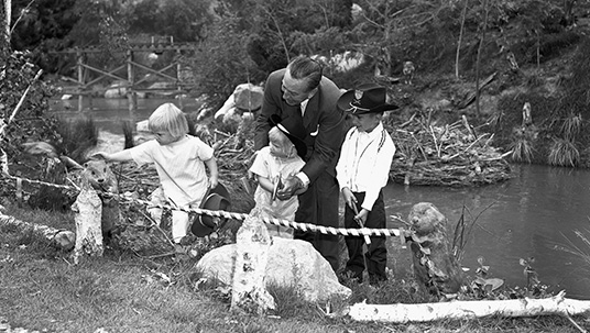 photo of Walt Disney with three of his grandchildren—Tammy, Joanna, and Chris Miller—and a family of friendly Audio-Animatronics® beavers