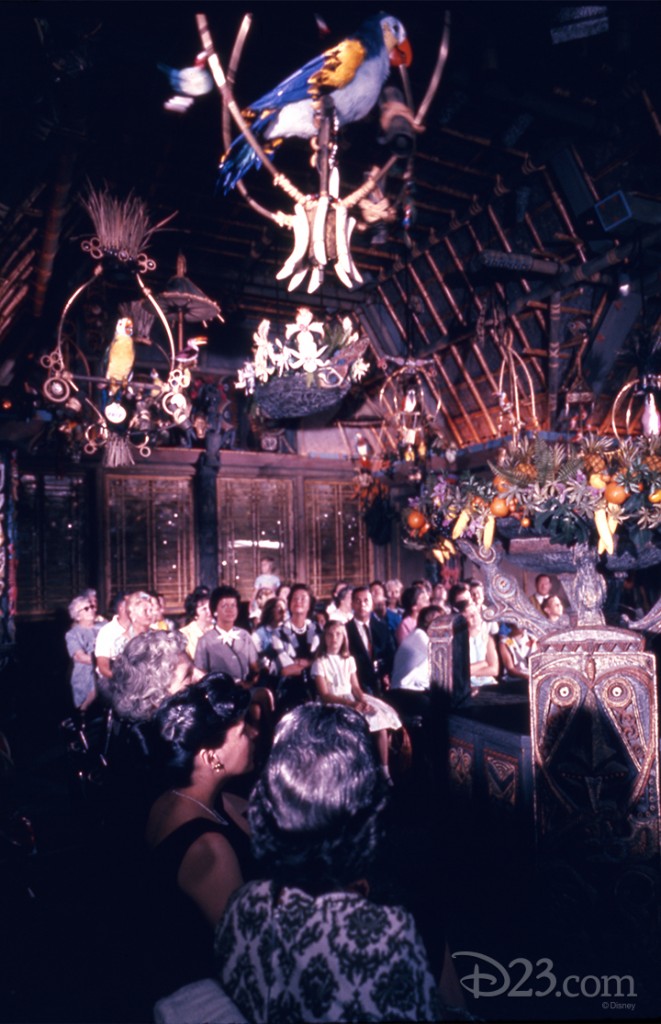 photo of well-dressed guests seated in interior of the enchanted tiki room looking up at perched birds