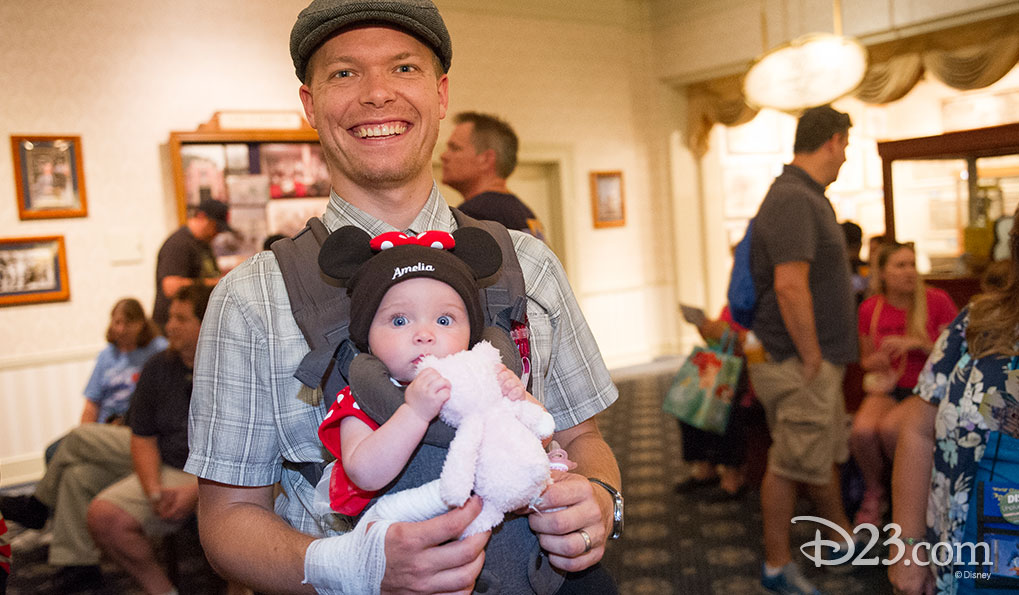 D23 member holding his baby daughter at the Opera House