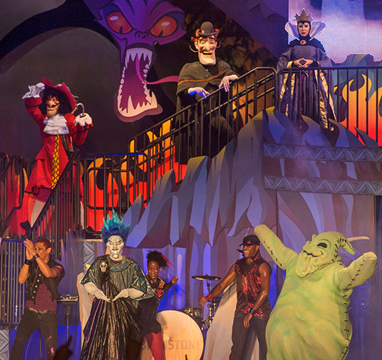 photo of several actors dressed as various villainous Disney characters on stage set