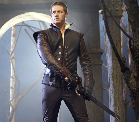 production photo of Josh Dallas in full leather outfit preparing to draw his sword