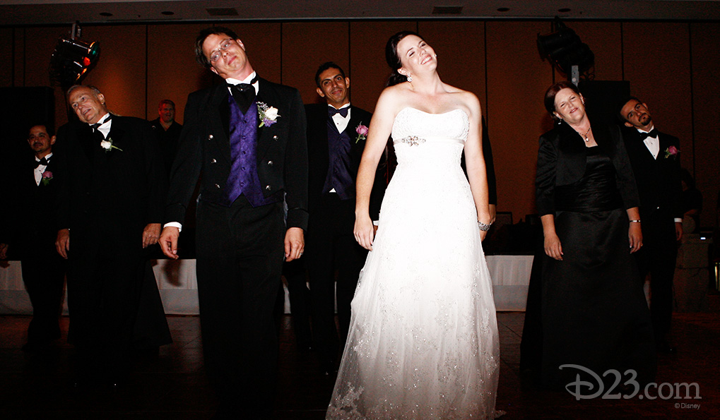 photo of bride and groom and several guests standing pretending to have broken necks with heads all lolling to one side
