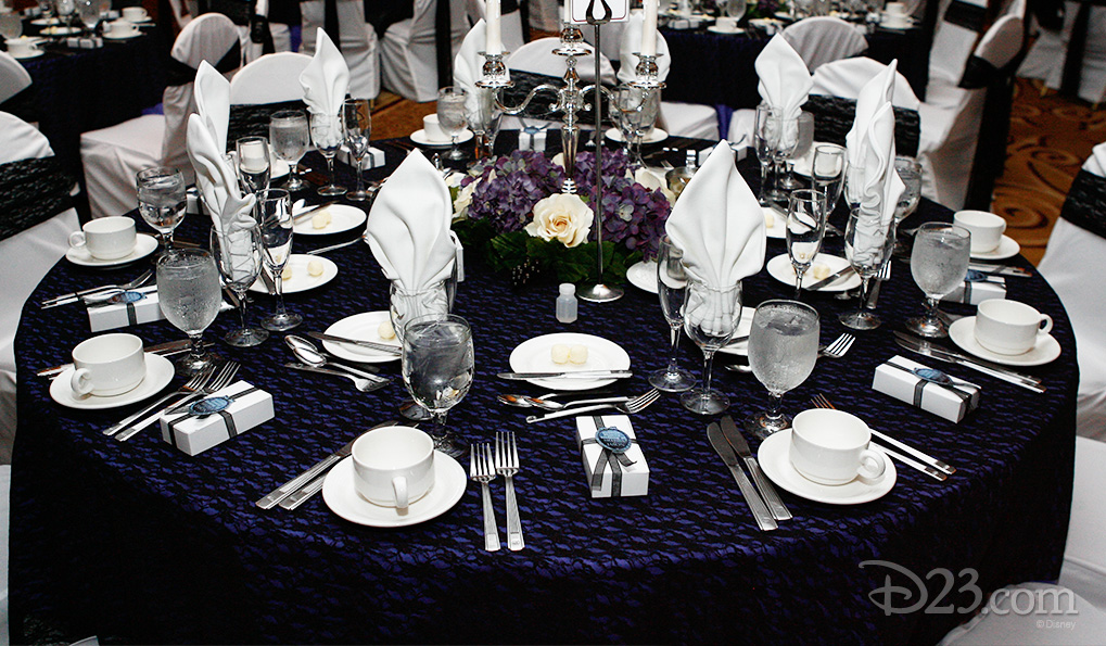 photo of reception dining table for guests laid out elaborately with each setting having a small wrapped gift box