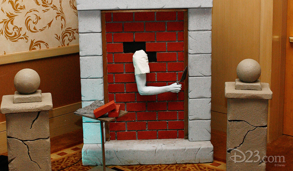 photo of disembodied arm sticking through bricked-up fireplace, with the arm doing the bricking-up