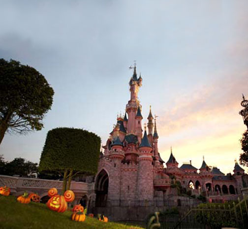 Festive jack-o'-lanterns dot the slopes surrounding Sleeping Beauty Castle at Disneyland Paris.