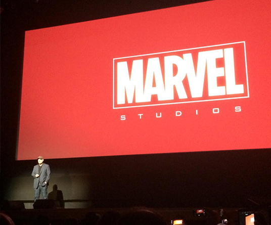 photo of Kevin Feige on stage beneath huge Marvel Studios graphic