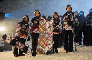 photo of group of young people dressed for winter sports, each person holding a snowboard