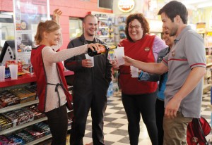 production group photo of four characters toasting each other with plastic cups
