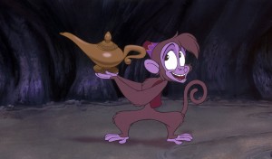 still from animated feature Aladdin featuring Abu the monkey in a cave holding Aladdin's Lamp