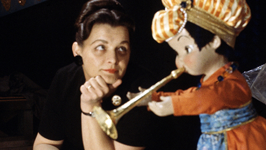 Disney Legend Alice Davis looking at a puppet