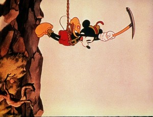 still of Mickey in climber gear dangling from a rope in Alpine Climbers