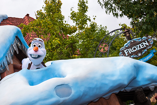 photo of talking Audio-Animatronic Olaf the Snowman popping up out of a snowdrift at the Frozen meeting spot at Disneyland