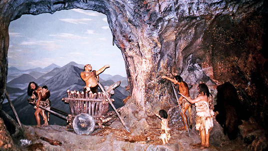 photo of caveman exhibit showing family using primitive tools