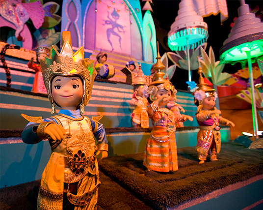 photo of colorfully dressed dolls standing on elaborately decorated stage