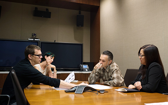 photo of Gris Grimly, Mike Moon and staff going over Haunted Mansion concept art in conference room