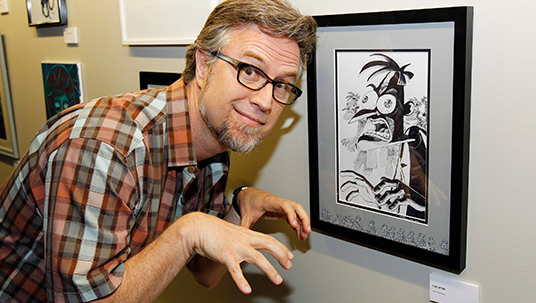 photo of Dan Povenmire with his framed illustration of a zombie character