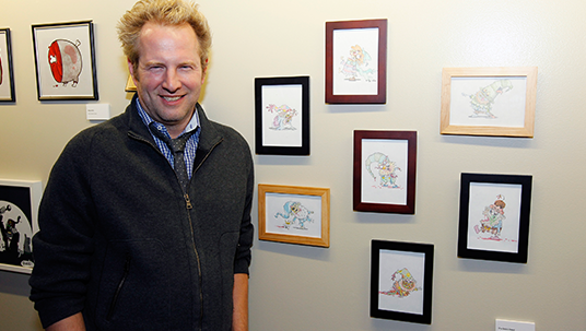 photo of The 7D co-executive producer Tom Warburton with his seven illustrations of the Seven Dwarfs