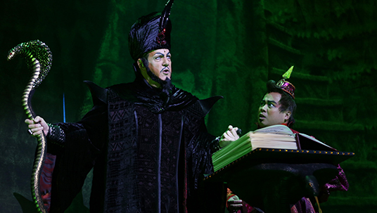 production photo of Jafar, played by Jonathan Freeman holding audiences in his spell