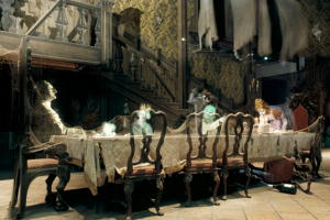 photo of Haunted Mansion Dining Room in Disneyland attraction showing ghostly apparitions seated at long formal dining table in a great hall