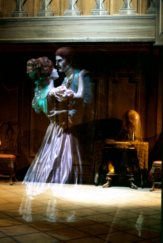 photo of interior of Disneyland's Haunted Mansion attraction showing ghostly couple dancing in great hall
